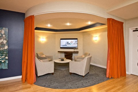 a living room with chairs and a table and a television